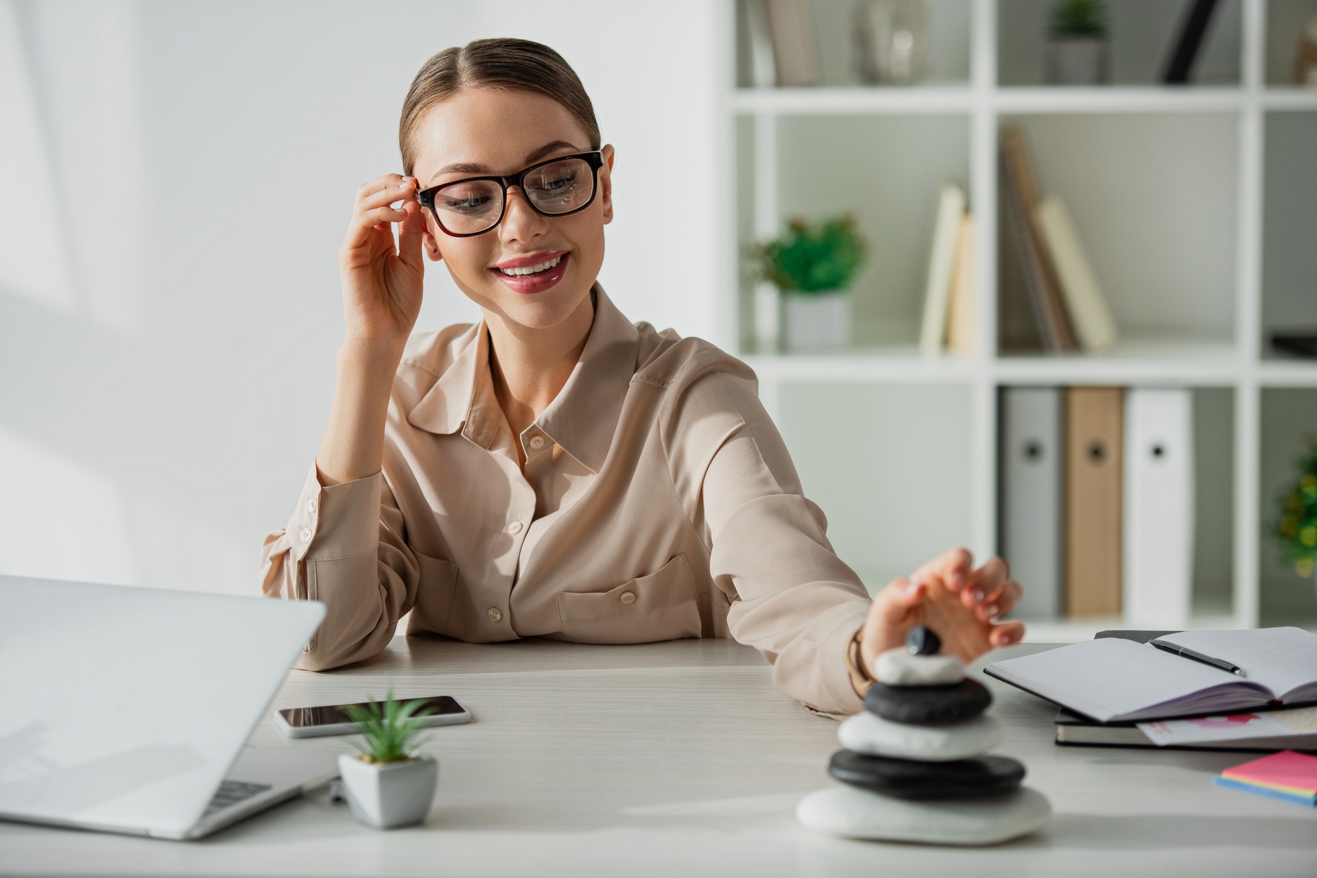 Frau schafft Balance am Arbeitsplatz mit Zen-Steinen | Enthärtungsanlage