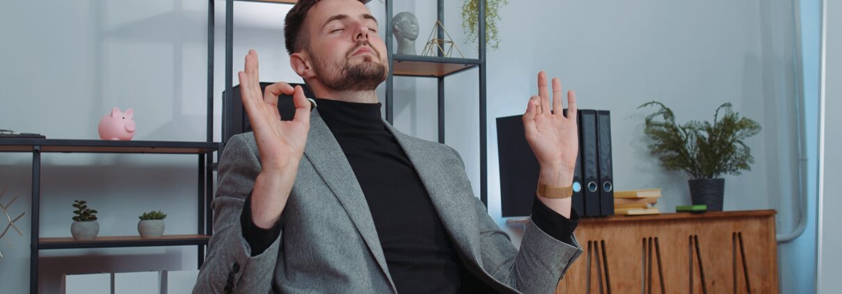Mann meditiert entspannt im Büro am Schreibtisch | Enthärtungsanlage